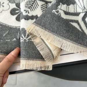 Close-up of thick jacquard scarf with floral patterns and dense fringe detail