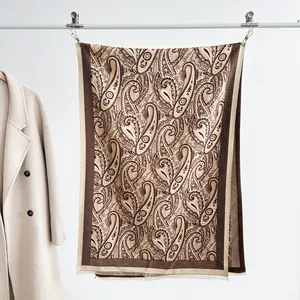 Close-up of vintage paisley pashmina shawl with tassel fringe on metal display