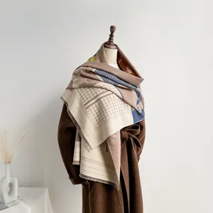 Dettaglio di morbida sciarpa in finto cashmere color-block con frange su un cappotto