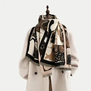 Detail of cashmere-like winter scarf with abstract art patterns and fringe on beige coat