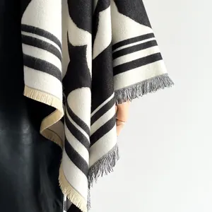 Détail d'un châle en maille noir et blanc avec texture épaisse et franges pour l'hiver