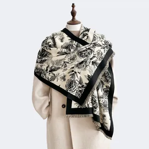 Close-up of floral cashmere feel shawl with black and white rose patterns and tassels