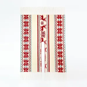 Nahaufnahme von Strickschal mit rotem Rentier- und Schneeflockenmuster und Fransen