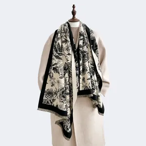 Detail of floral cashmere scarf with rose pattern and short fringe trim on mannequin