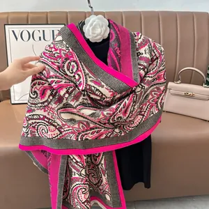 Detail of rose pink paisley scarf with an elegant white camellia flower brooch