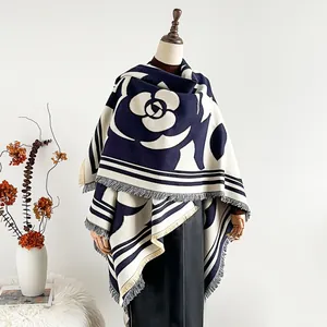 Châle en maille camélia épais avec rayures bleu marine et franges sur un mannequin