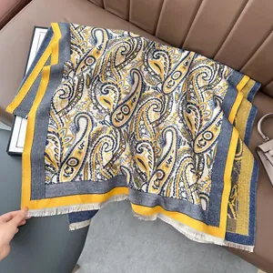 Detailed view of winter jacquard scarf with yellow paisley patterns and soft white tassels