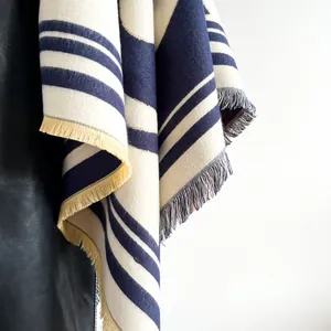 Gros plan sur un châle épais à rayures bleu marine et beige avec détails de franges
