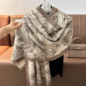 Detail of floral cashmere-feel scarf with fringe edges and warm beige rose pattern