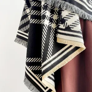 Detail of black and white geometric houndstooth pattern and tassel fringe on thick shawl