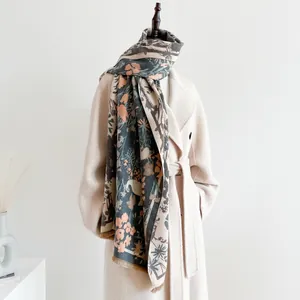 Close-up of floral jacquard pattern and fringe detail on vintage navy cashmere scarf