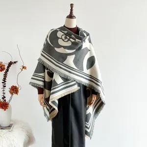 Détail du motif camélia et des franges sur ce châle en maille épaisse et chaude