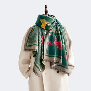 Detail of dark green scarf showing horse patterns and fine tassels on beige coat