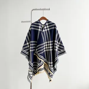 Detail of navy blue and beige plaid cashmere poncho with fine tassel fringe on a hanger