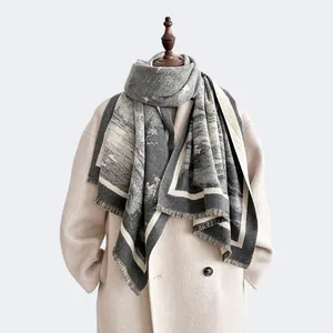 Detail of grey landscape cashmere feel scarf with tassels on white wool coat