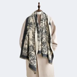 Elegant black and white floral cashmere scarf with fringe details on a fashion mannequin