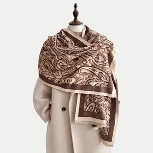 Detail of vintage paisley pattern on beige cashmere scarf with elegant fringe trim