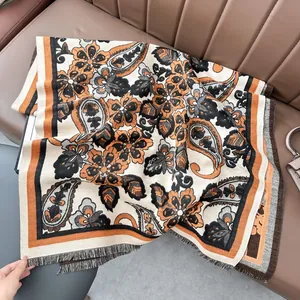 Détail d'un châle jacquard à motif cachemire avec franges sur une surface en cuir