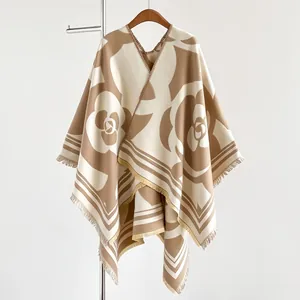 Détails du motif camélia et des franges sur un poncho en maille épaisse pour femme