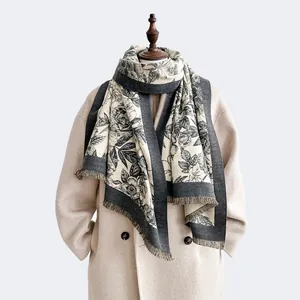 Detailed view of floral pattern and tassel edges on a thick cashmere-style winter scarf