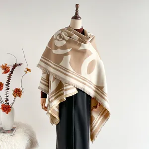 Détail du motif camélia sur châle épais en cachemire camel avec bordure frangée