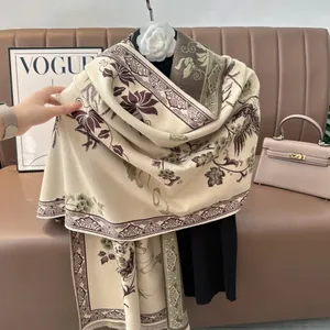 Dettaglio macro dello scialle floreale beige con frange su sfondo in pelle pregiata