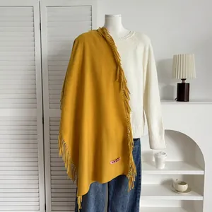 Détail de l'écharpe jaune moutarde avec maille épaisse et finitions à longues franges