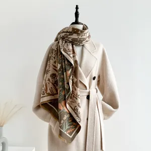 Detailed view of heavy floral cashmere scarf with fringe paired with a wool coat