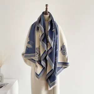 Detail der floralen Jacquard-Musterung und Fransen an einem navyblauen und beigen Paschmina