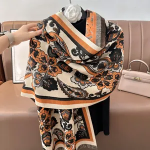 Détail d'un châle épais en cachemire à motif paisley vintage orange et noir élégant