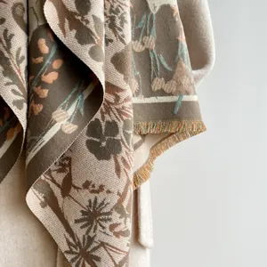 Close-up of vintage floral knit scarf with detailed tassel edges and soft wool texture