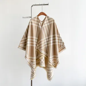 Detail of plaid faux cashmere cape with fringe hem and split front design in earth tones