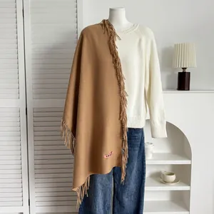 Détail de l'écharpe camel aspect cachemire avec de longues franges et étiquette rose