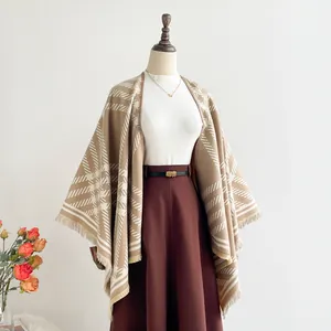 Close-up of beige plaid cashmere shawl with fringe trim and stylish metal belt detail