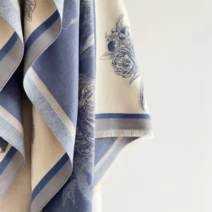 Detailansicht des eleganten floralen Jacquard-Musters und der feinen Fransen am Schal