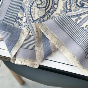 Close-up of blue Paisley jacquard scarf showing soft cashmere texture and fringe detail
