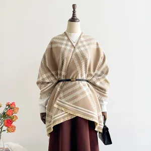 Detail of beige geometric cashmere shawl featuring fine tassels and black leather belt