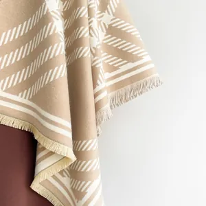Detail of soft cashmere feel shawl featuring geometric stripes and fringe edges