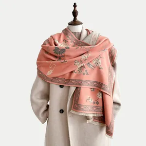 Dettaglio della scialle in cashmere rosa con motivi floreali grigi e frange