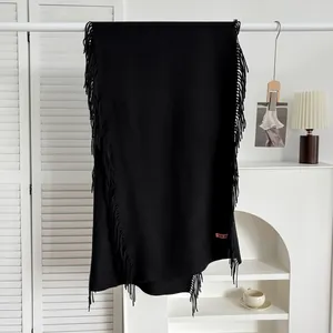 Détail de l'écharpe en cachemire noir avec bords à franges et étiquette tissée de marque
