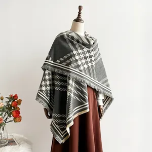 Women's cashmere-like split poncho with geometric plaid pattern and fringe detail