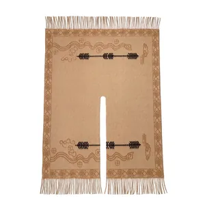 Detailed view of ethnic pattern embroidery and tassel fringe on beige cashmere shawl