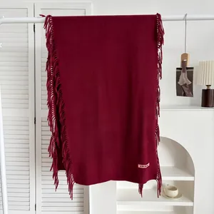 Vue détaillée d'une écharpe bordeaux style cachemire avec texture douce et franges