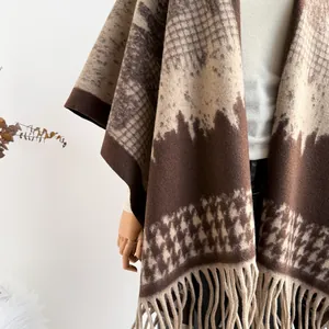 Detail of vintage houndstooth thick shawl with long fringe and wool-like texture