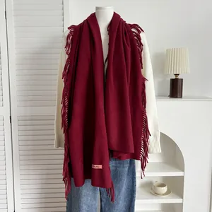 Détail de l'écharpe bordeaux aspect cachemire avec franges et étiquette de marque