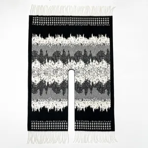 Detail of classic houndstooth poncho shawl with black and white patterns and long fringe