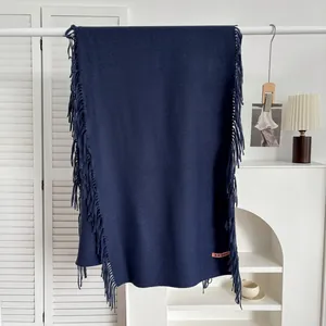 Détails de l'écharpe en cachemire bleu marine avec franges et étiquette rose brodée