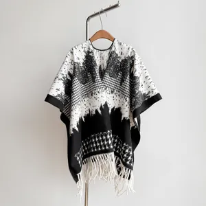 Detail of British style houndstooth wool cape with elegant tassels and geometric textures