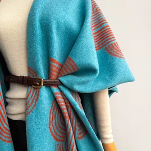 Ethnic style light blue shawl with orange geometric patterns and warm fringed wool texture