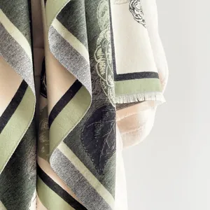 Nahaufnahme des Floral-Jacquard-Schals mit weicher Kaschmir-Textur und Fransen
